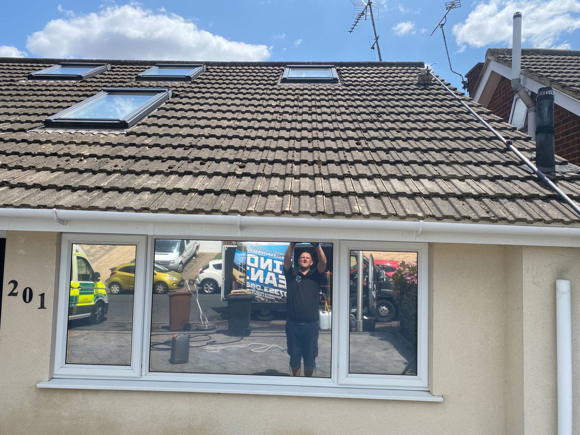 Mossy concrete tile roof viewed wider — before scraping